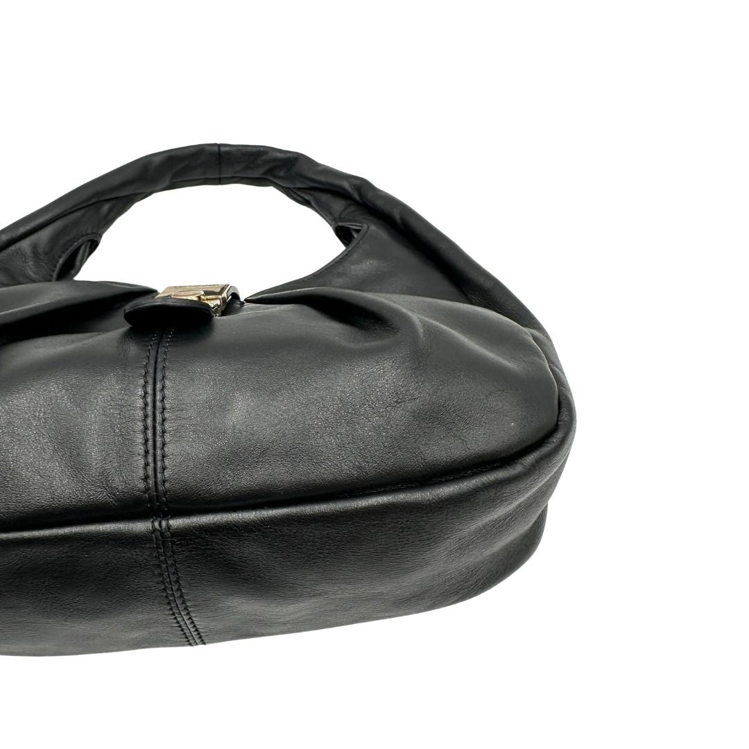 Angolo di una borsa modello hobo Borbonese in morbida pelle nera, con metalleria dorata, usata, originale, second hand, in ottime condizioni.
