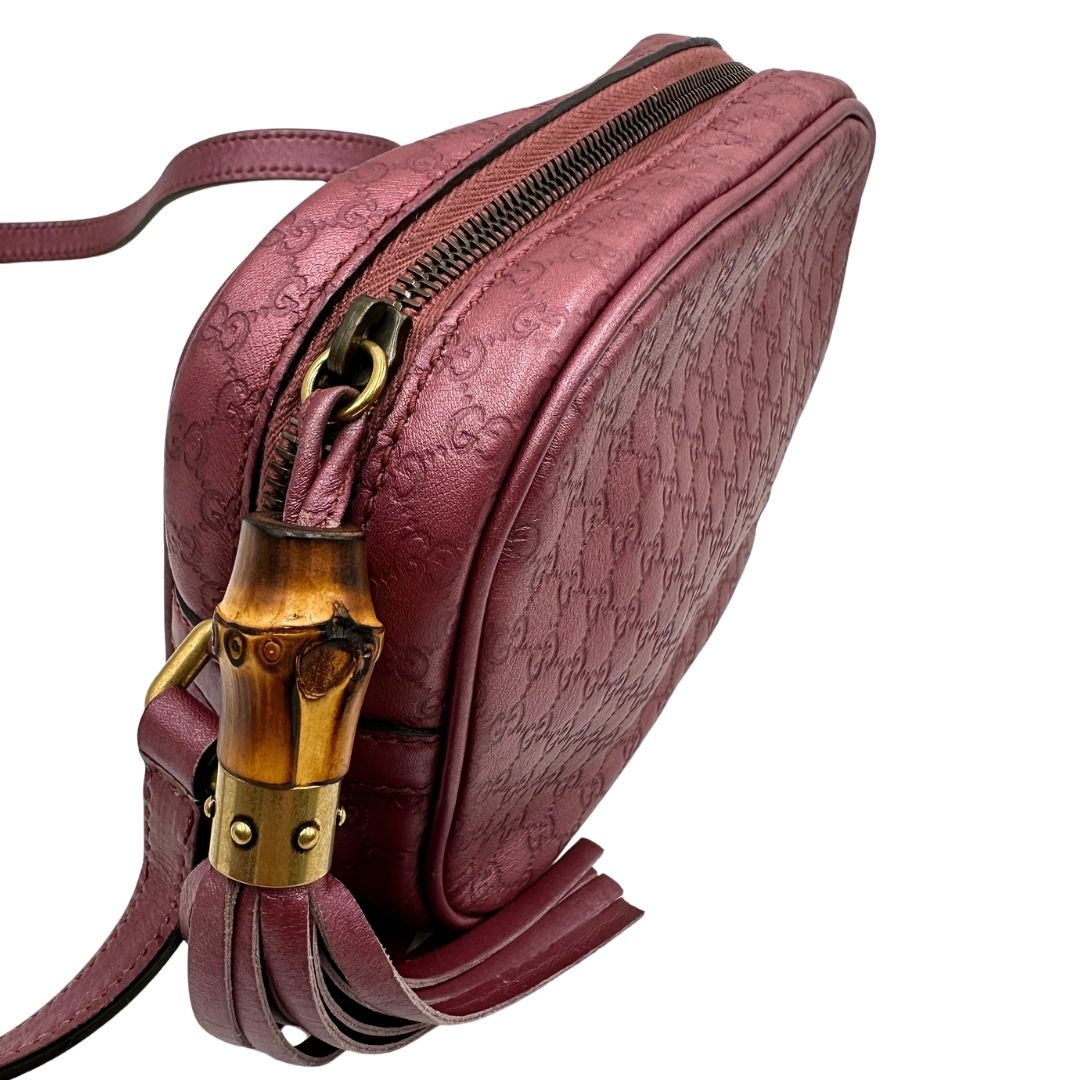 Dettaglio della chiusura di una tracolla Gucci Microguccissima in color rosa metallizzato, con nappa decorativa con dettaglio bambù