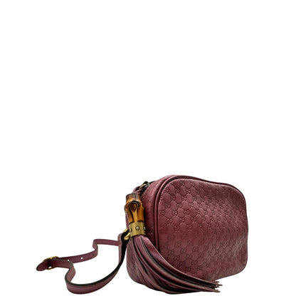 Laterale sinistro di una tracolla Gucci Microguccissima in color rosa metallizzato, con nappa decorativa con dettaglio bambù