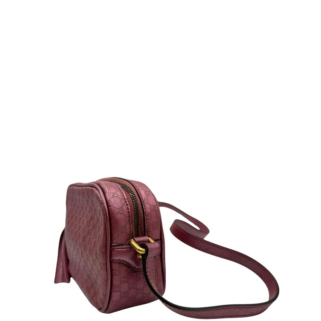 Laterale destro di una tracolla Gucci Microguccissima in color rosa metallizzato, con nappa decorativa con dettaglio bambù