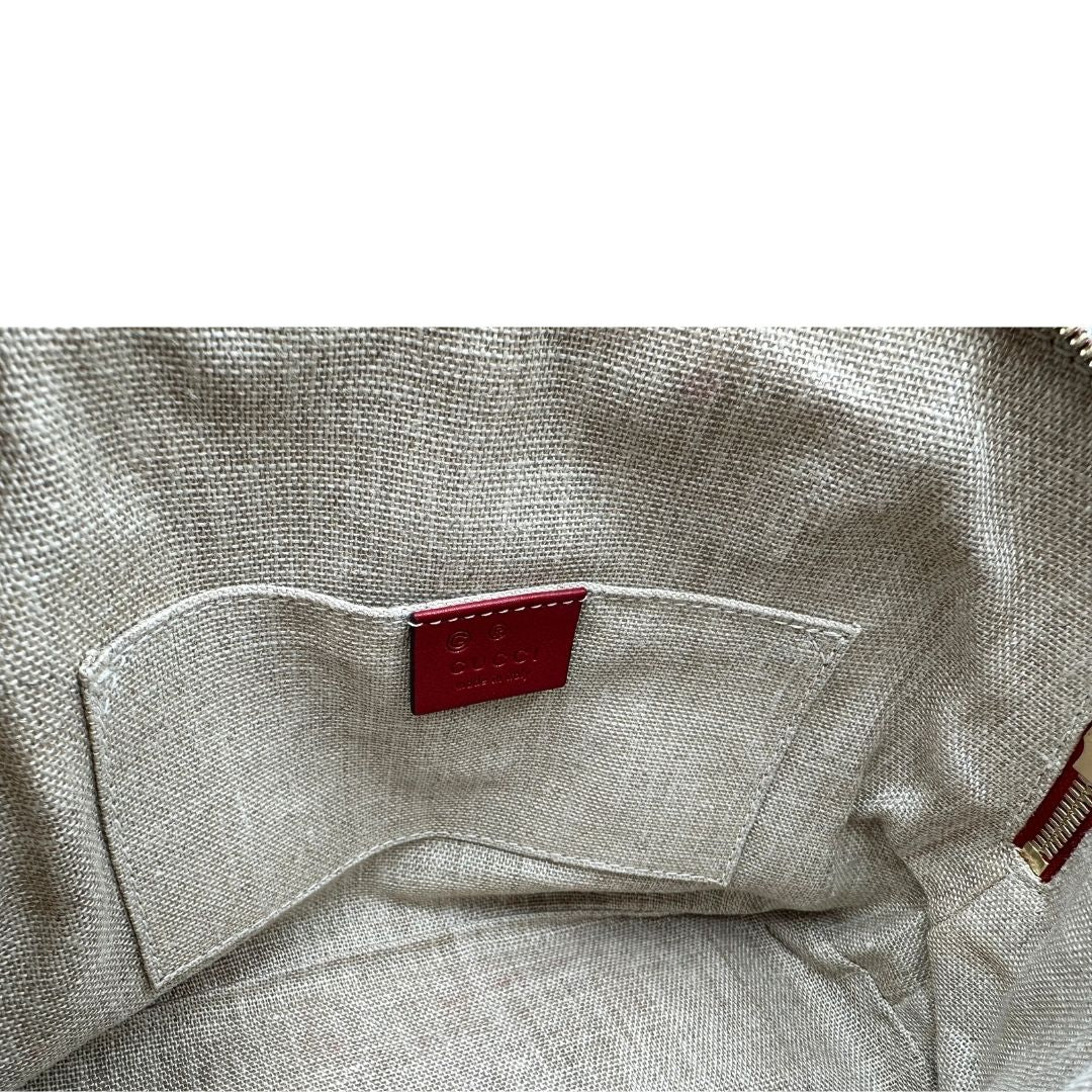 Interno di una tracolla Gucci Microguccissima in color rosso ciliegia, con metalleria dorata, usata, originale, second hand, in ottime condizioni.