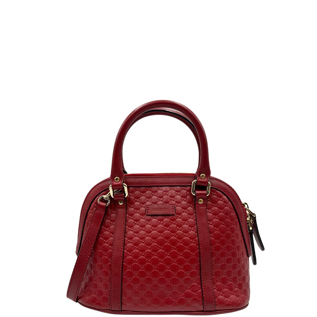 Front di una tracolla Gucci Microguccissima in color rosso ciliegia, con metalleria dorata, usata, originale, second hand, in ottime condizioni.