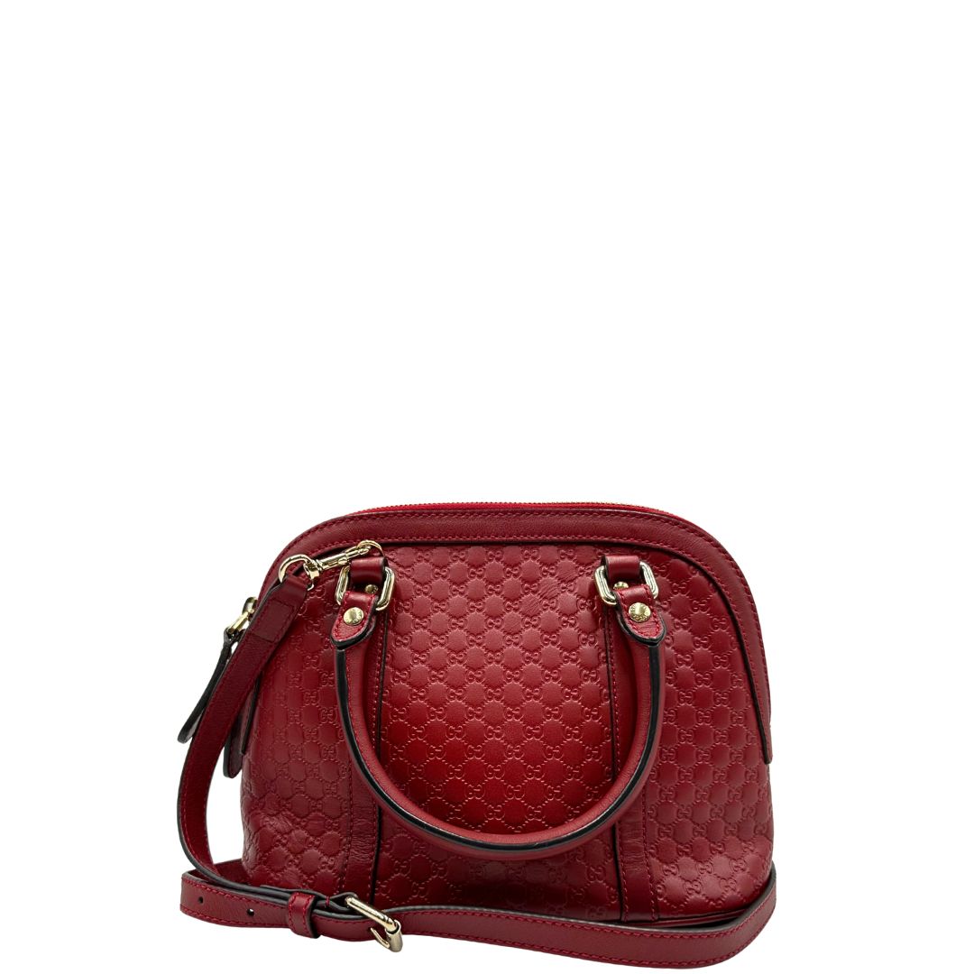 Retro di una tracolla Gucci Microguccissima in color rosso ciliegia, con metalleria dorata, usata, originale, second hand, in ottime condizioni.