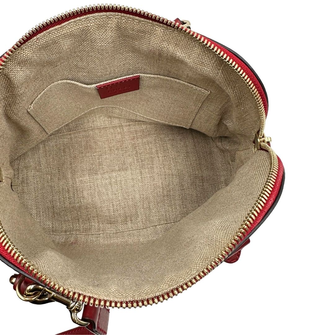 Interno di una tracolla Gucci Microguccissima in color rosso ciliegia, con metalleria dorata, usata, originale, second hand, in ottime condizioni.