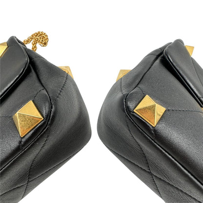 angoli Borsa V.G. in pelle nera impreziosita da iconiche borchie piramidali dorate, di lusso, originale, ottime condizioni, usata. 