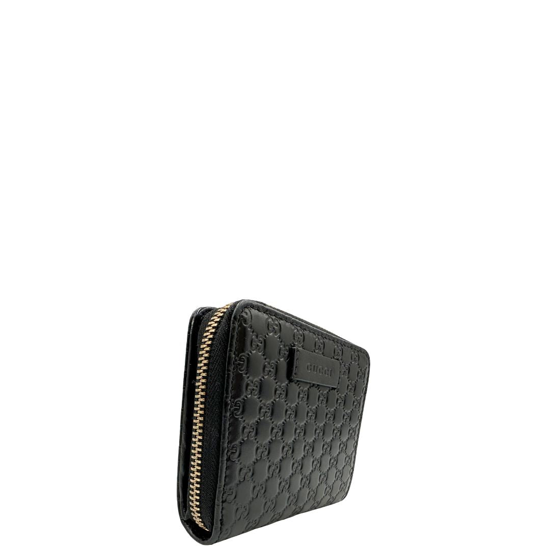 Lato destro, Portafoglio Gucci in pelle GG nera con hardware dorato. Originale, usato, di lusso, in ottime condizioni.