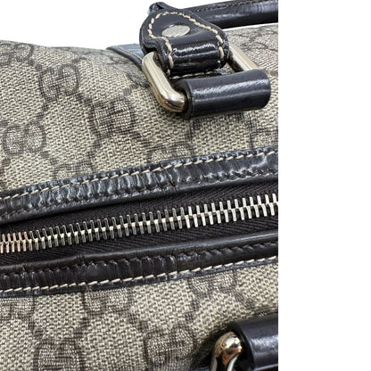 Difetti sulla pelle di un bauletto Gucci Supreme in canvas beige e dettagli in pelle marroni.