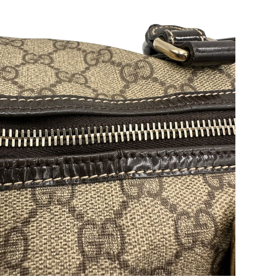 Difetti sul pellame di un bauletto Gucci Supreme in canvas beige e dettagli in pelle marroni.