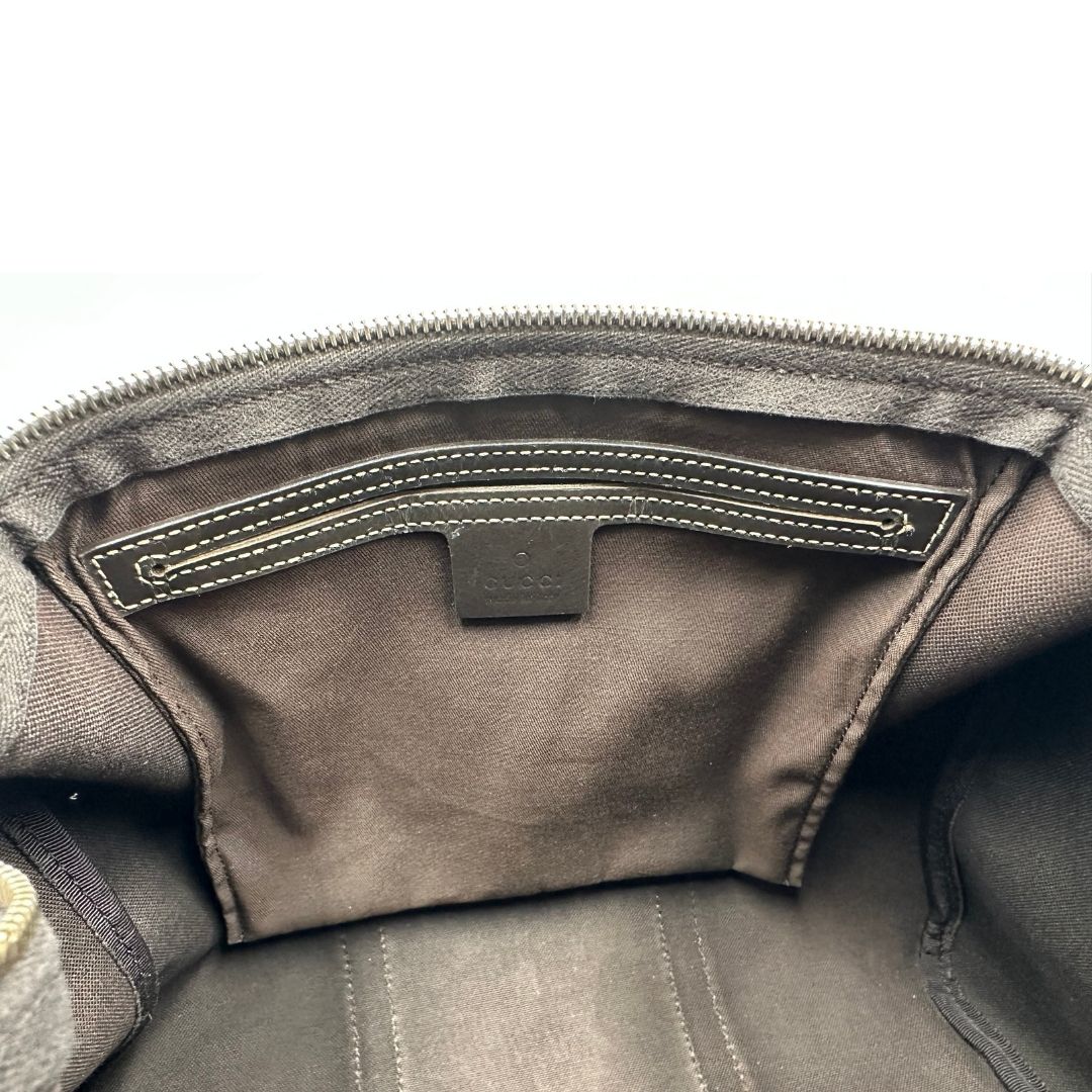 Interno di un bauletto Gucci Supreme in canvas beige e dettagli in pelle marroni.