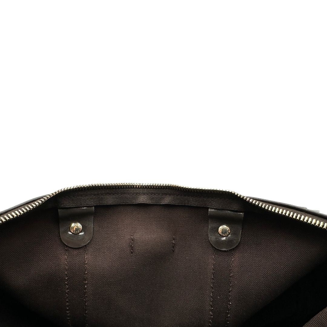 Interno di un bauletto Gucci Supreme in canvas beige e dettagli in pelle marroni.