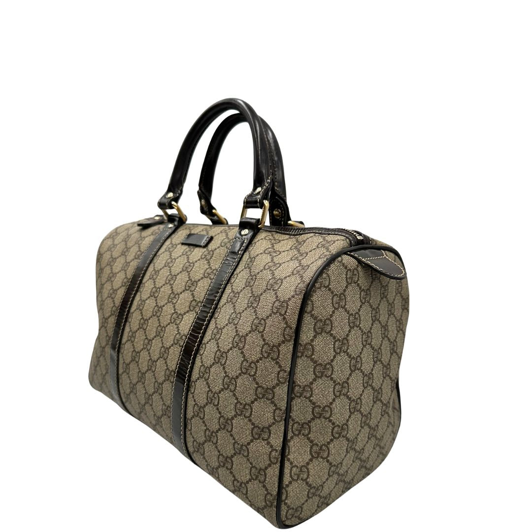 Laterale destro di un bauletto Gucci Supreme in canvas beige e dettagli in pelle marroni.