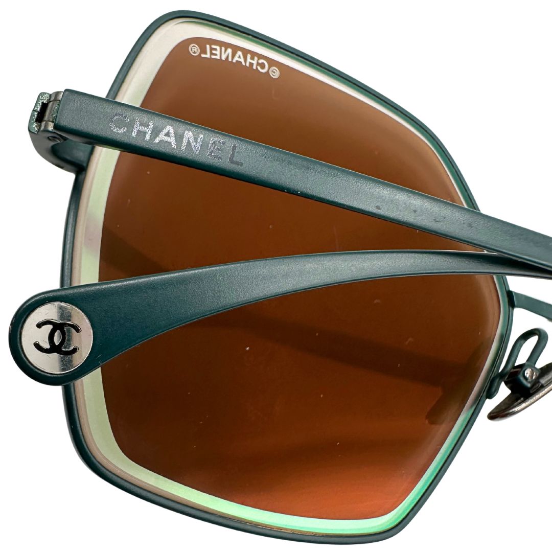 Aste di un paio di occhiali da sole Chanel dal design quadrato con aste verde petrolio e lenti cangianti, usati, originali, second hand, in ottime condizioni.