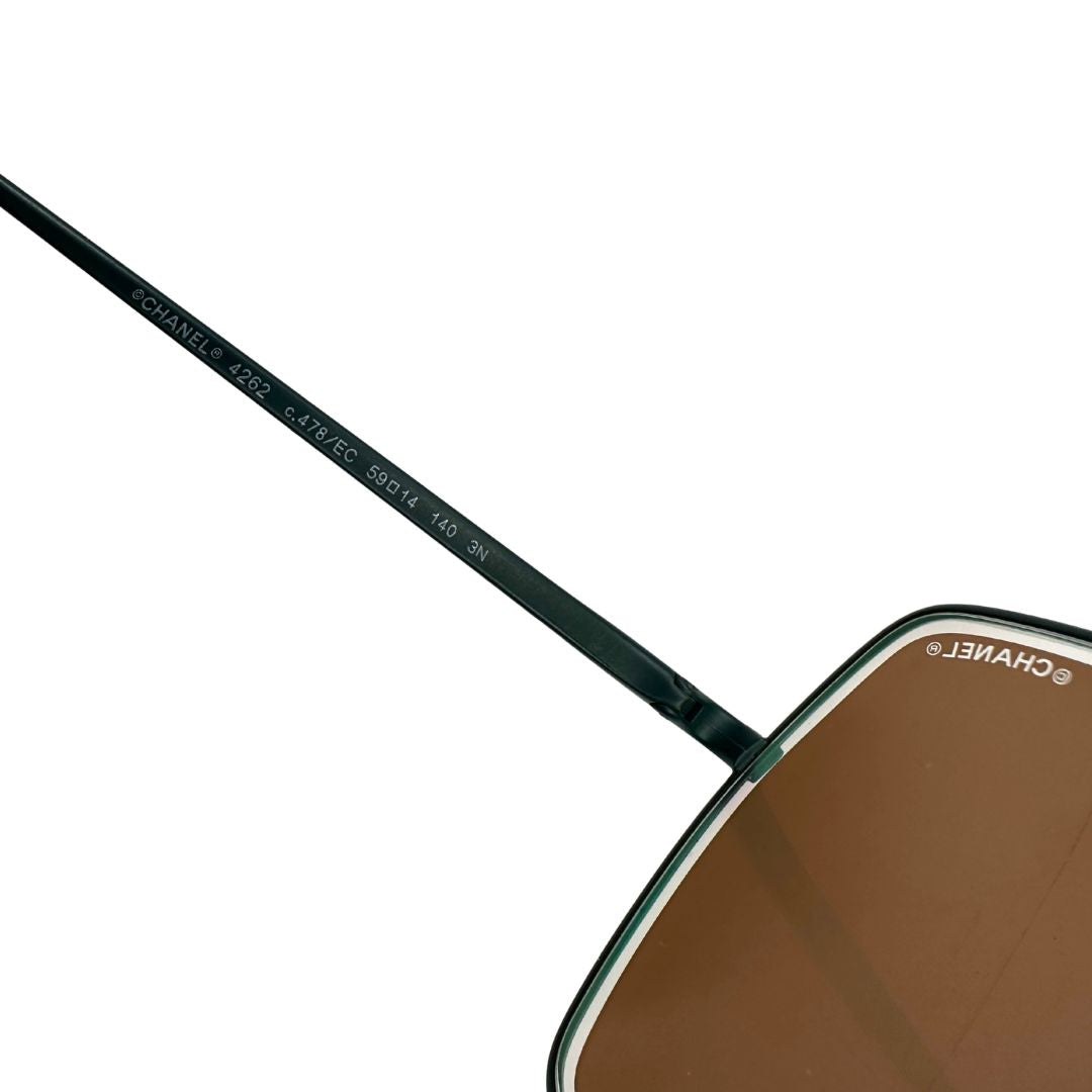 Interno di un'asta di un paio di occhiali da sole Chanel dal design quadrato con aste verde petrolio e lenti cangianti, usati, originali, second hand, in ottime condizioni.