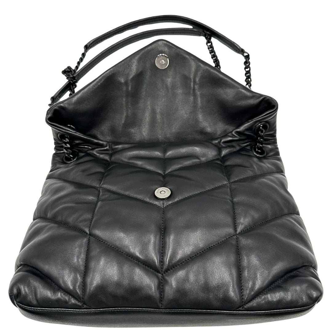 Apertura di una borsa Saint Laurent in pelle con impunture trapuntate, con parti metalliche in ottone nero, indossabile a spalla o a tracolla, usata, originale, second hand, in ottime condizioni.