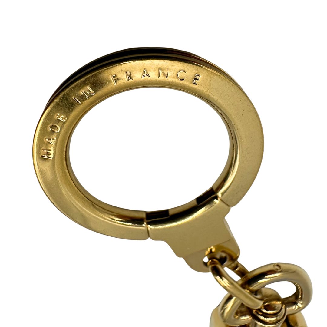 Made in di un charm portachiavi LV in metallo dorato, corredato, usato, originale, second hand, in ottime condizioni.