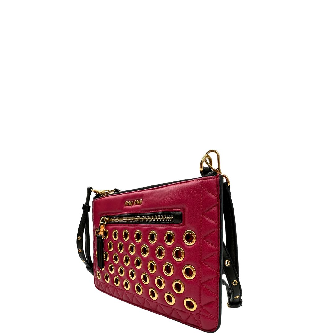 Laterale destro di una pochette con tracolla Miu Miu Biker in morbida nappa vele color azalea e hardware dorato, caratterizzata da occhielli metallici, usata, originale, second hand, in ottime condizioni.