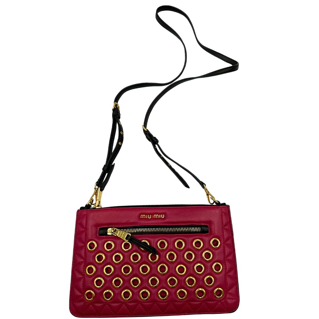 Front di una pochette con tracolla Miu Miu Biker in morbida nappa vele color azalea e hardware dorato, caratterizzata da occhielli metallici, usata, originale, second hand, in ottime condizioni.