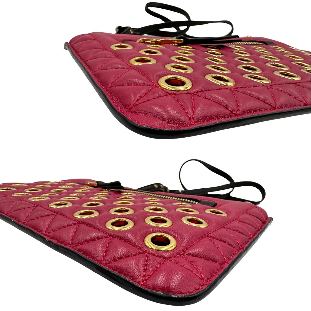 Angoli di una pochette con tracolla Miu Miu Biker in morbida nappa vele color azalea e hardware dorato, caratterizzata da occhielli metallici, usata, originale, second hand, in ottime condizioni.