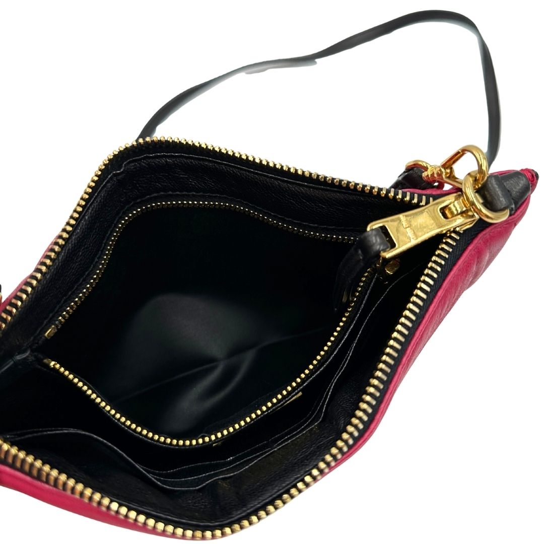 Interno di una pochette con tracolla Miu Miu Biker in morbida nappa vele color azalea e hardware dorato, caratterizzata da occhielli metallici, usata, originale, second hand, in ottime condizioni.