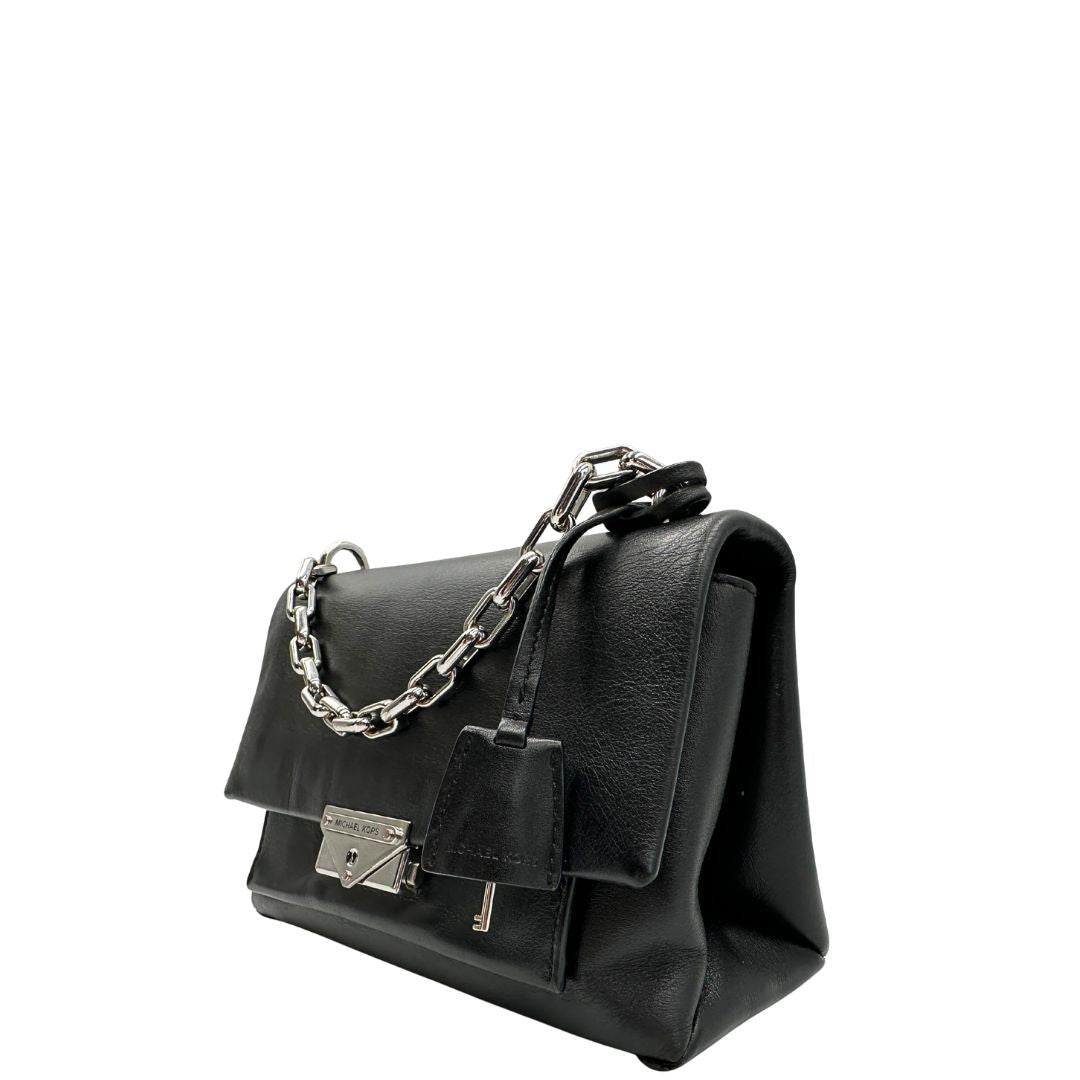 Lato sinistro, Borsa MK in pelle con impunture trapuntate, con parti metalliche in ottone nero, indossabile a spalla o a tracolla. Originale, usata, di lusso, in ottime condizioni.
