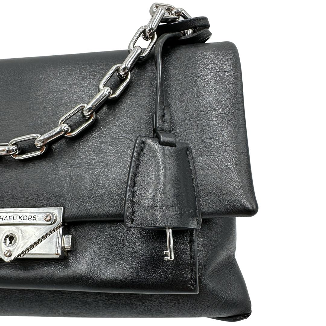 Borsa MK in pelle con impunture trapuntate, con parti metalliche in ottone nero, indossabile a spalla o a tracolla. Originale, usata, di lusso, in ottime condizioni.