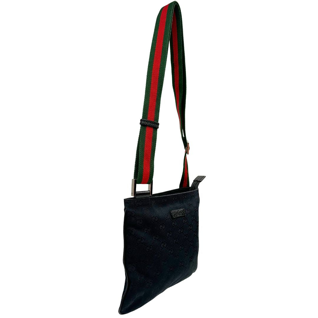 Laterale sinistro di una borsa Gucci GG con tracolla Web regolabile e finiture in pelle nere, usata, originale, second hand, in ottime condizioni.