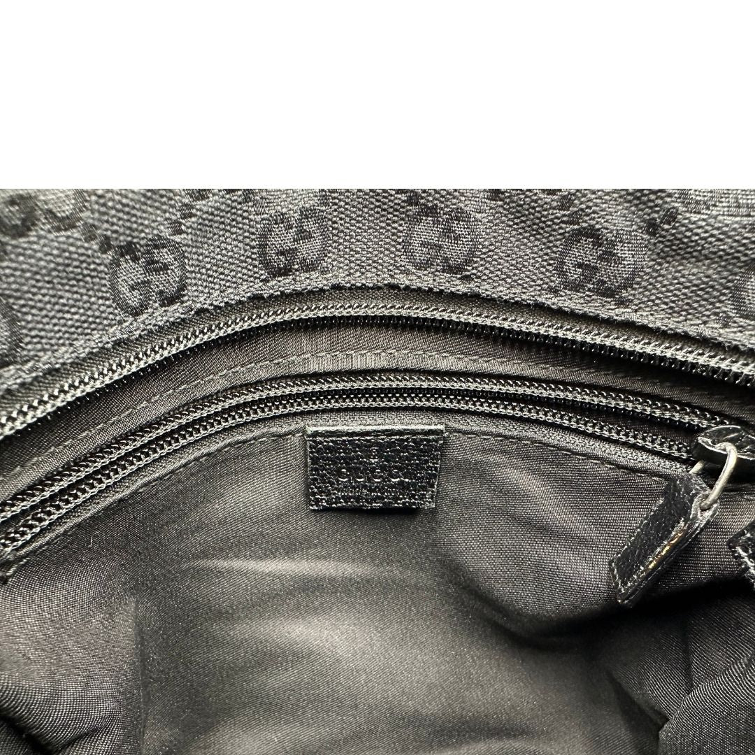 Interno di una borsa Gucci GG con tracolla Web regolabile e finiture in pelle nere, usata, originale, second hand, in ottime condizioni.