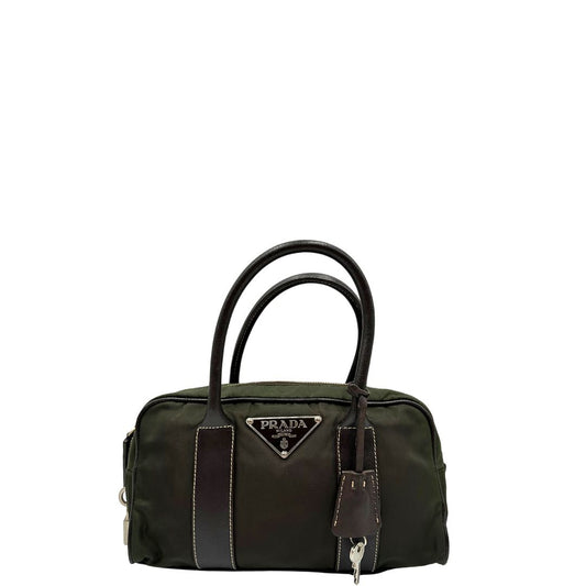 Front di un bauletto Prada in tessuto nylon verde militare e pelle marrone, con dettagli metallici argentati, indossabile a mano.