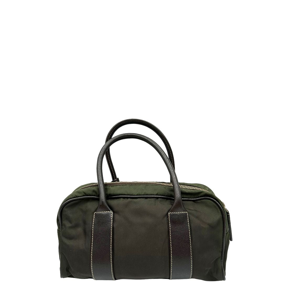 Retro di un bauletto Prada in tessuto nylon verde militare e pelle marrone, con dettagli metallici argentati, indossabile a mano.