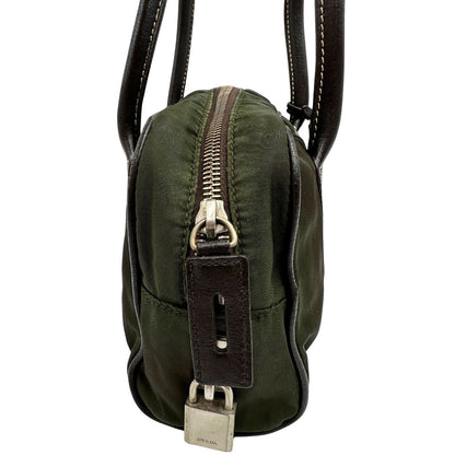 Vista laterale di un bauletto Prada in tessuto nylon verde militare e pelle marrone, con dettagli metallici argentati, indossabile a mano.