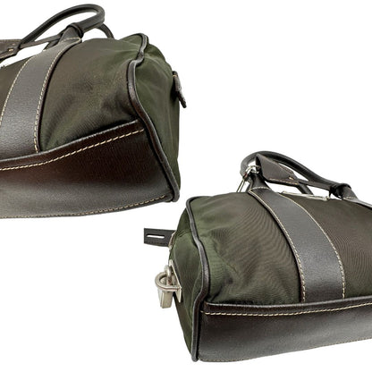 Angoli di un bauletto Prada in tessuto nylon verde militare e pelle marrone, con dettagli metallici argentati, indossabile a mano.