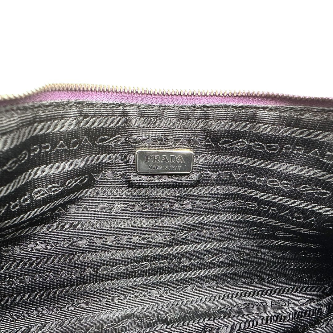 Interno di una borsa Prada in nylon viola, indossabile a spalla, usata, originale, second hand, in ottime condizioni.