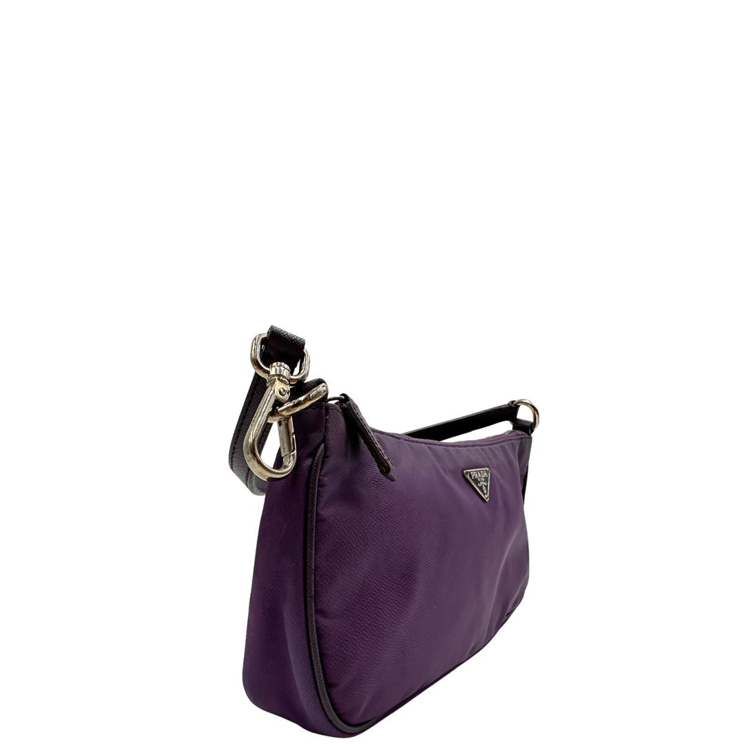 Laterale sinistro di una borsa Prada in nylon viola, indossabile a spalla, usata, originale, second hand, in ottime condizioni.