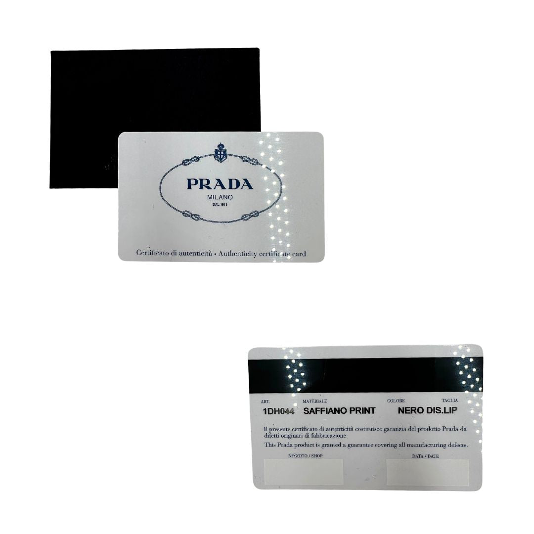 Card d'autenticità di un Prada WOC in pelle saffiano nera, decorato con una vivace stampa di rossetti. Indossabile a tracolla oppure a mano, usato, originale, second hand, in ottime condizioni.