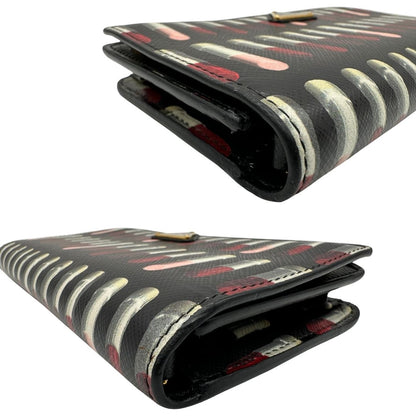 Angoli di un Prada WOC in pelle saffiano nera, decorato con una vivace stampa di rossetti. Indossabile a tracolla oppure a mano, usato, originale, second hand, in ottime condizioni.