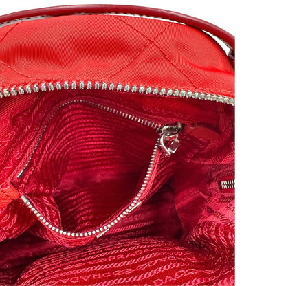 Interno di uno zaino Prada in tessuto sintetico rosso e finiture in pelle tono su tono, usato, originale, second hand, in ottime condizioni.