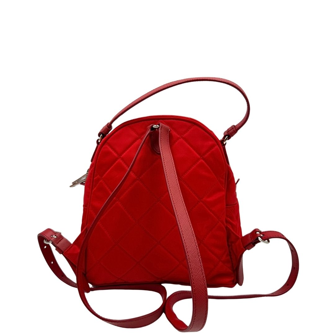 Retro di uno zaino Prada in tessuto sintetico rosso e finiture in pelle tono su tono, usato, originale, second hand, in ottime condizioni.