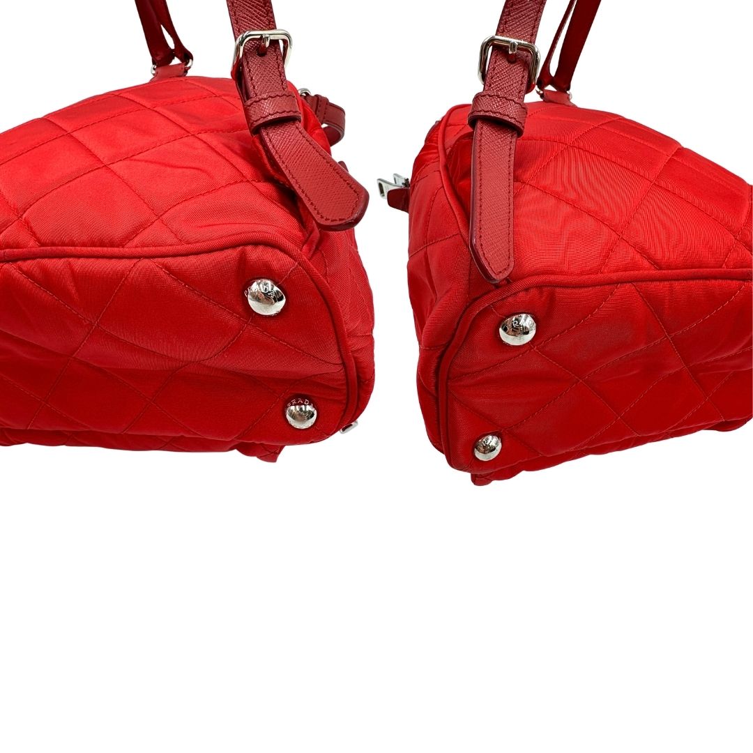 Angoli di uno zaino Prada in tessuto sintetico rosso e finiture in pelle tono su tono, usato, originale, second hand, in ottime condizioni.