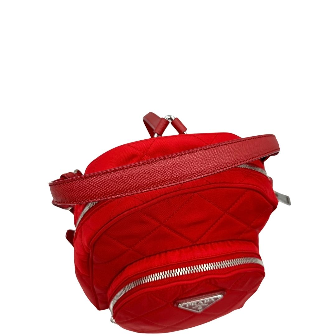 Manico superiore di uno zaino Prada in tessuto sintetico rosso e finiture in pelle tono su tono, usato, originale, second hand, in ottime condizioni.