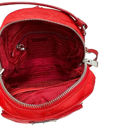 Interno di uno zaino Prada in tessuto sintetico rosso e finiture in pelle tono su tono, usato, originale, second hand, in ottime condizioni.