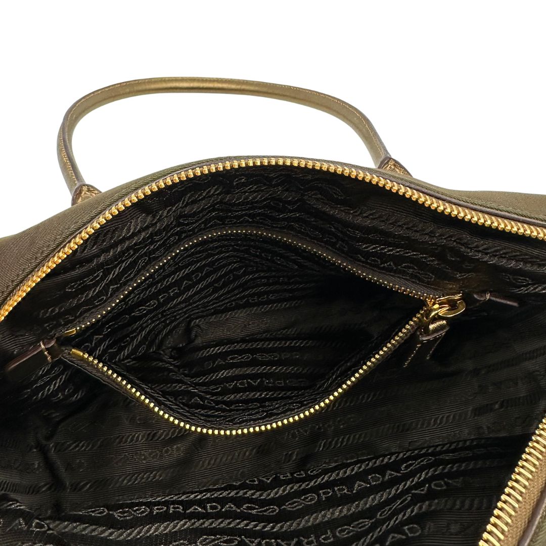 Interno di un bauletto Prada in tessuto nylon e pelle saffiano bronzo, con dettagli metallici dorati, indossabile a spalla, usato, originale, second hand, in ottime condizioni.