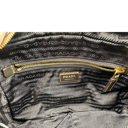 Interno di un bauletto Prada in tessuto nylon e pelle saffiano bronzo, con dettagli metallici dorati, indossabile a spalla, usato, originale, second hand, in ottime condizioni.