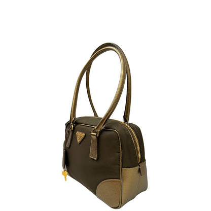 Laterale destro di un bauletto Prada in tessuto nylon e pelle saffiano bronzo, con dettagli metallici dorati, indossabile a spalla, usato, originale, second hand, in ottime condizioni.