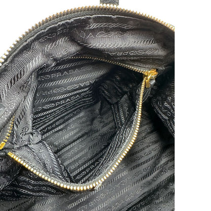Interno di un bauletto Prada in tessuto vela e dettagli dorati, indossabile a mano, usato, originale, second hand, in ottime condizioni.