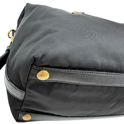 Angolo di un bauletto Prada in tessuto vela e dettagli dorati, indossabile a mano, usato, originale, second hand, in ottime condizioni.