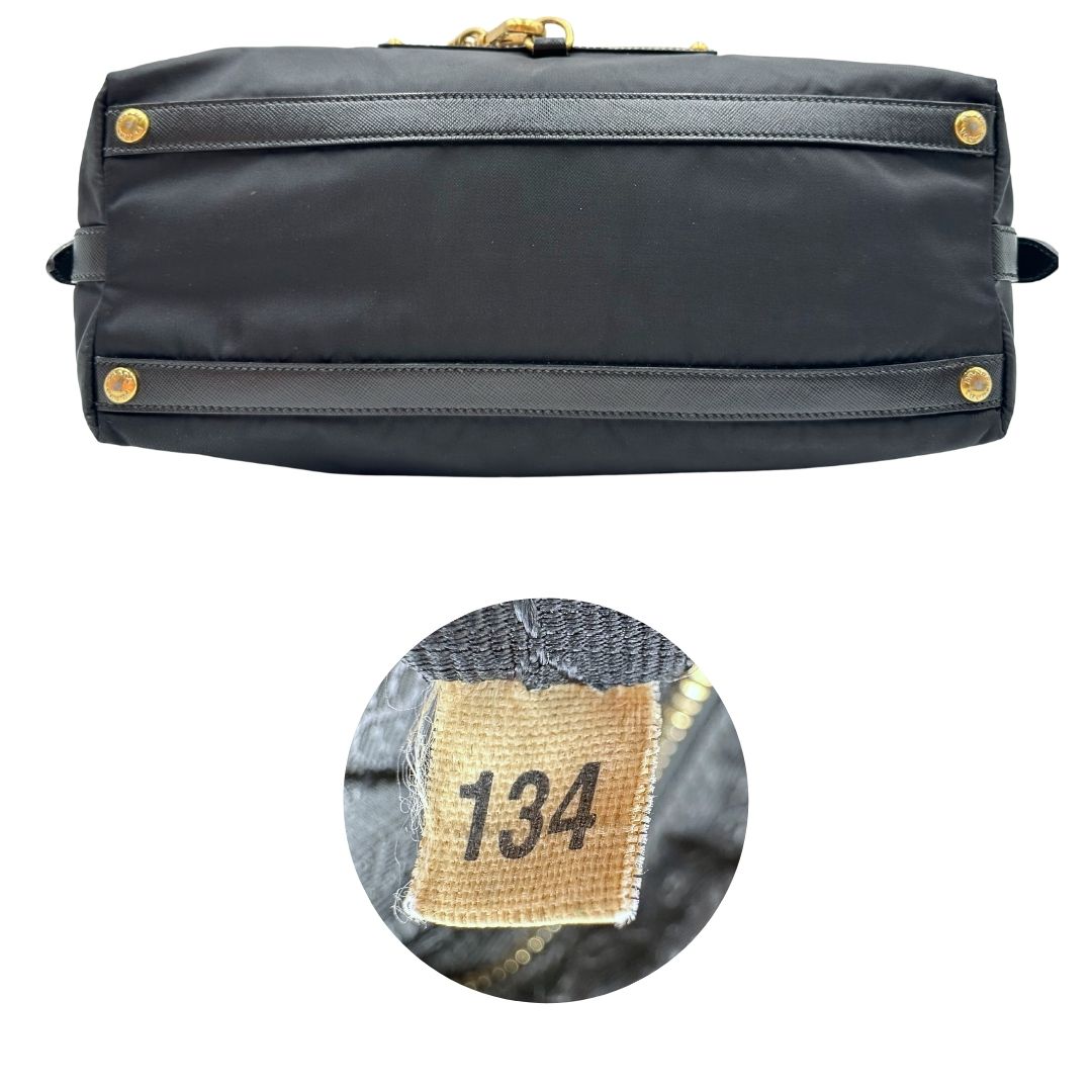 Base e codice di un bauletto Prada in tessuto vela e dettagli dorati, indossabile a mano, usato, originale, second hand, in ottime condizioni.