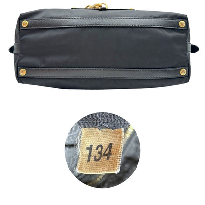 Base e codice di un bauletto Prada in tessuto vela e dettagli dorati, indossabile a mano, usato, originale, second hand, in ottime condizioni.