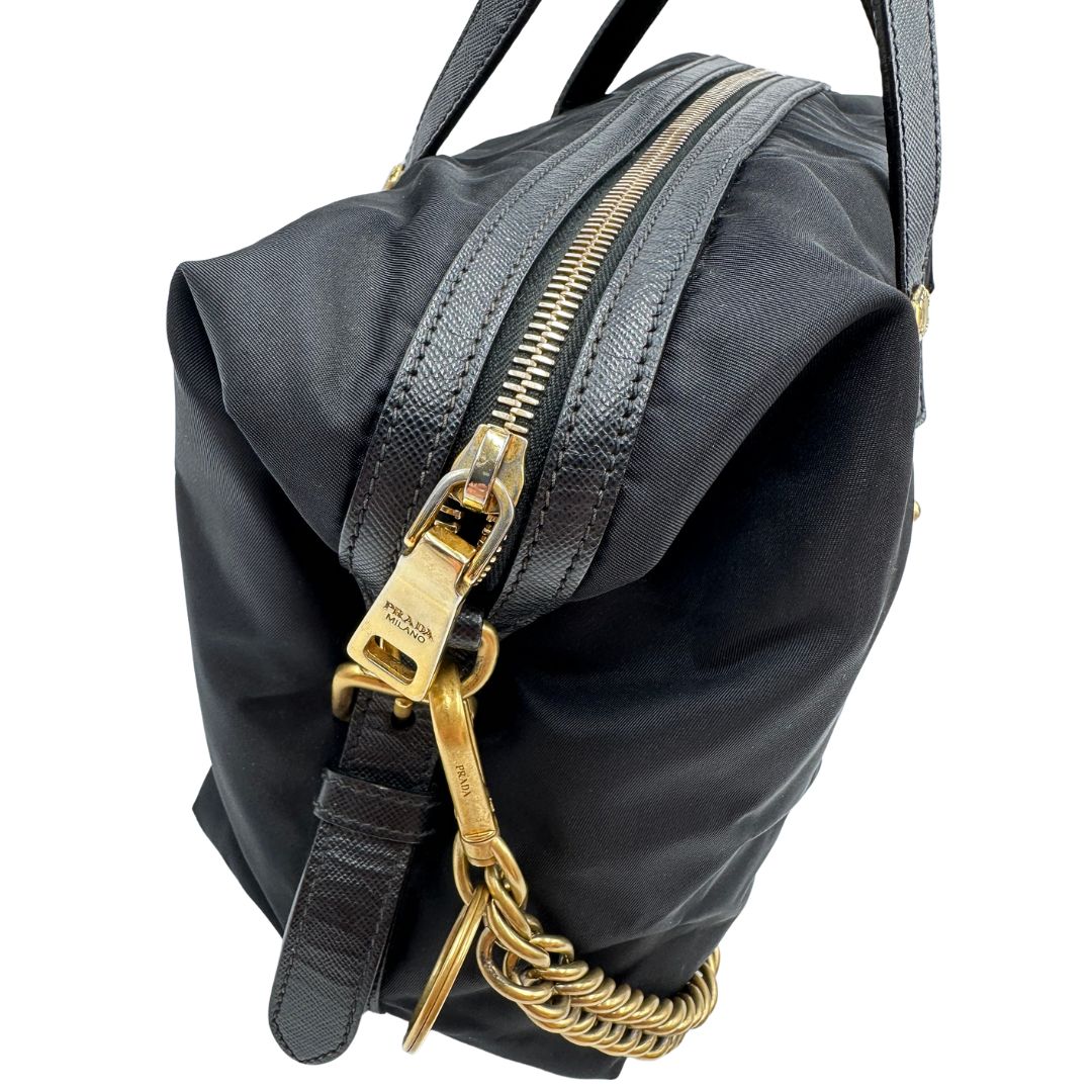 Parti metalliche di un bauletto Prada in tessuto vela e dettagli dorati, indossabile a mano, usato, originale, second hand, in ottime condizioni.