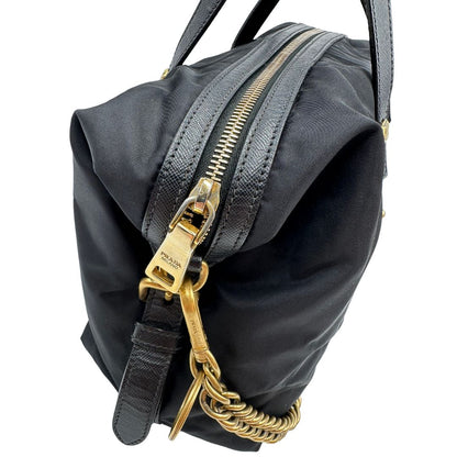 Parti metalliche di un bauletto Prada in tessuto vela e dettagli dorati, indossabile a mano, usato, originale, second hand, in ottime condizioni.