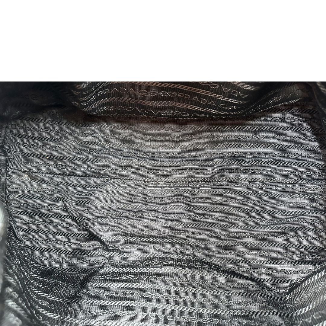 Interno di un bauletto Prada in tessuto vela e dettagli dorati, indossabile a mano, usato, originale, second hand, in ottime condizioni.